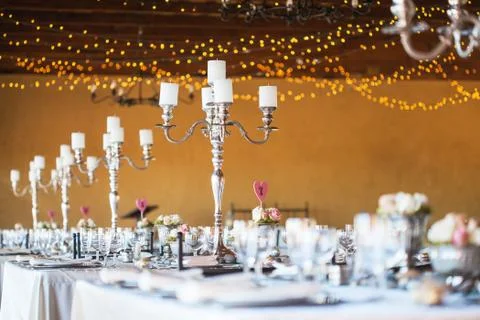 Wedding reception hall with decor including candles, cutlery and crockery Stock Photos
