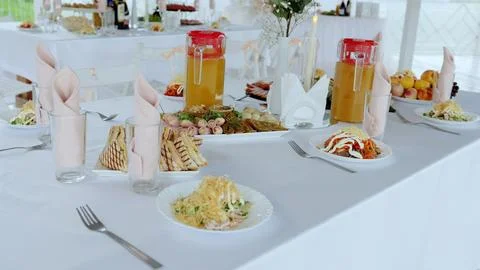 Wedding reception table featuring elegant pink napkins, diverse gourmet Stock Photos