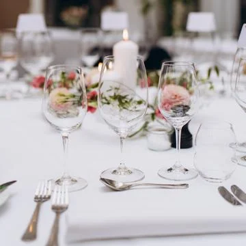 Wedding reception table in the restaurant decorated with white candles and fl Stock Photos