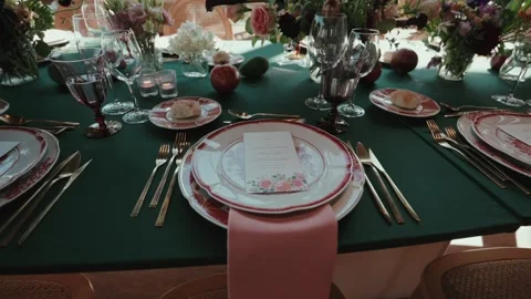Wedding reception table setting with plates glasses flowers and candles Stock Footage 333111336