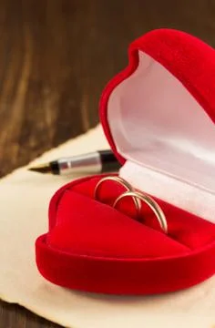 Wedding ring and aged paper on wood Stock Photos