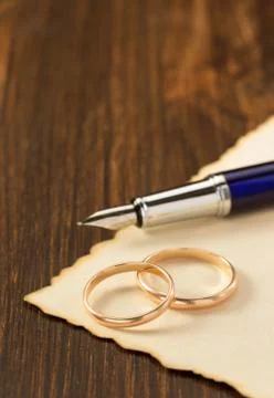 Wedding ring and aged paper on wood Stock Photos