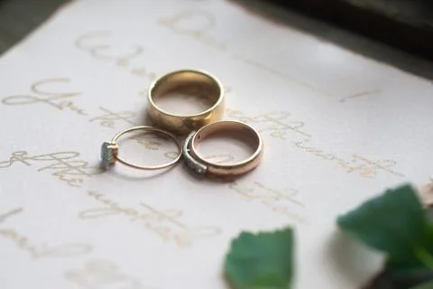 Wedding ring and invitation on table Stock Photos