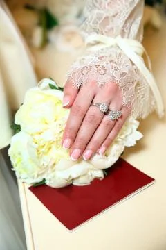 A wedding ring appears on the bride's hand. Marriage Certificate on the table Stock Photos