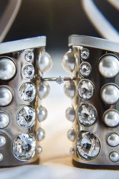 Wedding ring between wedding shoes and highlights Stock Photos
