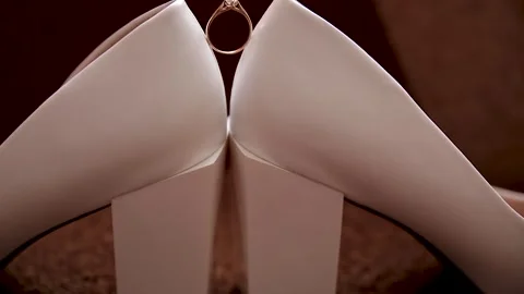 Wedding ring between white shoes. Stock Footage 249010162