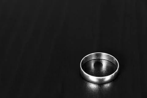 A wedding ring on a black table Stock Photos