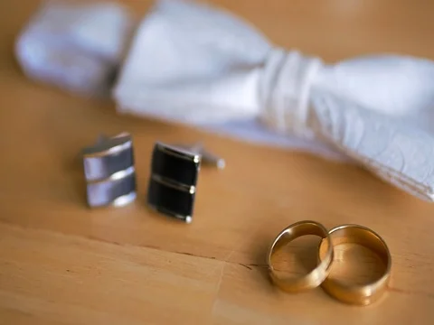 Wedding ring, bow tie and cufflinks are on the table Stock Footage 78808824