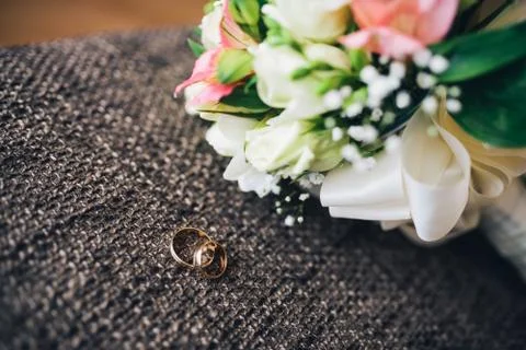 Wedding ring in a box and bride's bouquet Stock Photos