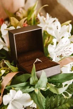 Wedding ring in a box close-up, gold ring with a diamond in flowers. Weddin.. Stock Photos