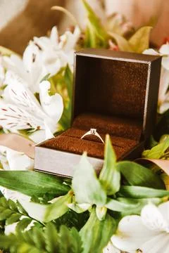 Wedding ring in a box close-up, gold ring with a diamond in flowers. Weddin.. Stock Photos