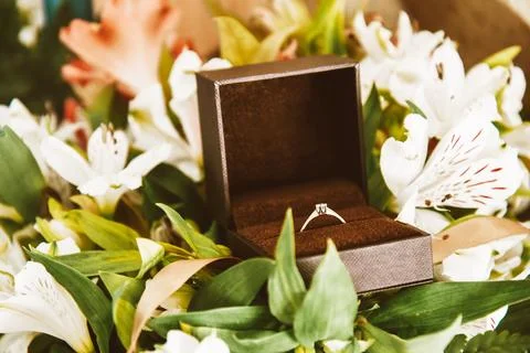 Wedding ring in a box close-up, gold ring with a diamond in flowers. Weddin.. Stock Photos