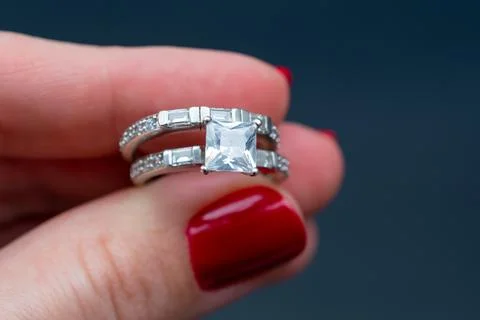 Wedding ring with diamond in hand on a dark background. Stock Photos