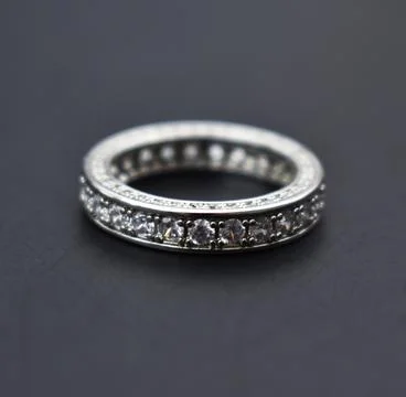 Wedding ring with diamonds on a dark background closeup. Stock Photos