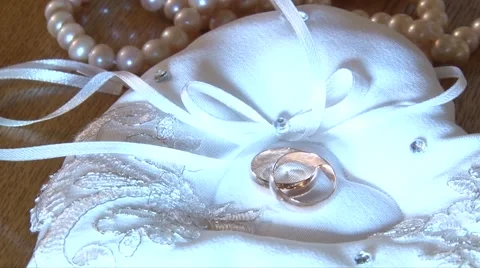 Wedding ring lies on a bed in a heart next to the other decorations Stock Footage 55795685