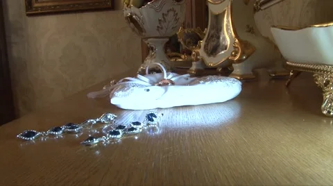 Wedding ring lies on a bed in a heart next to the other decorations Stock Footage 55795694