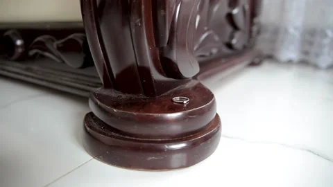 The wedding ring lies on an expensive leg of an antique sofa made of natural Stock Footage 170607409