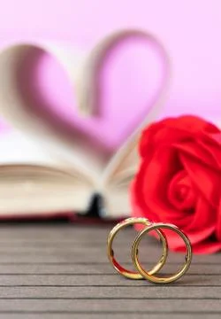 Wedding ring with pages of book curved heart shape with red rose Stock Photos