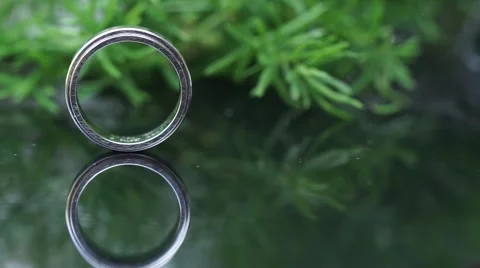 Wedding Ring rolling to another  - Macro Dolly Shot Stock Footage 64008726