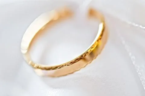 Wedding ring on a satiny fabric (macro) Stock Photos