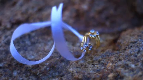 Wedding ring tight by white ribbon video shot Stock Footage 92863551