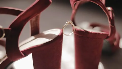 Wedding ring on woman's burgundy red shoes. Wedding ring on the bride shoes Stock Footage 131337017