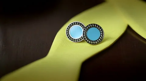 Wedding rings and cufflinks on a yellow bow tie. Slider shot Stock Footage 44685300