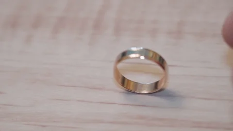 Wedding rings and play with the light on the wooden background close-up Stock Footage 129094101