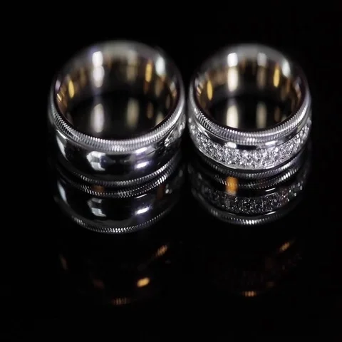 Wedding rings black background shining with light close up macro Stock Footage 69394996