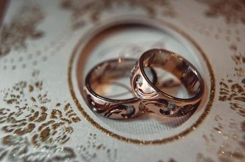Wedding rings with carving pattern on a wedding invitation Stock Photos