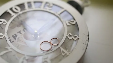 Wedding rings on the clock Stock Footage 63254297