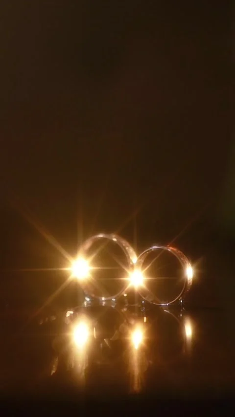 Wedding rings close-up on a dark background with light Stock-Footage 337893130
