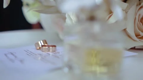 Wedding rings close-up on the table with wedding bouquet Stock Footage 251947909