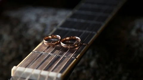 Wedding rings on guitar strings Stockbeeldmateriaal 123894363