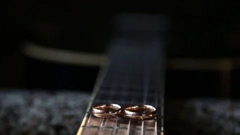 Wedding rings on guitar strings Stockbeeldmateriaal 123894385