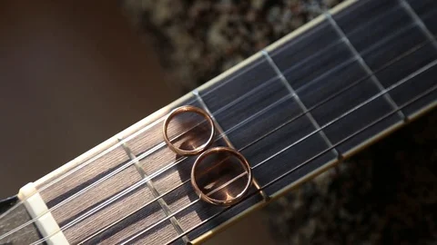 Wedding rings on guitar strings Stockbeeldmateriaal 123894448