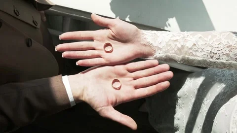Wedding rings held in hands during intimate wedding ceremony outdoors Stock Footage 317606680