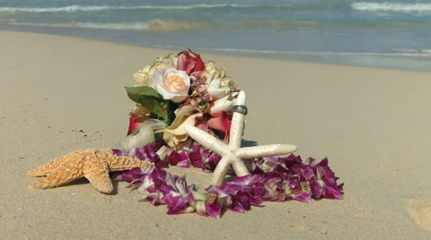 Wedding rings, lei and startfish beach love concept Stock Footage 57706842