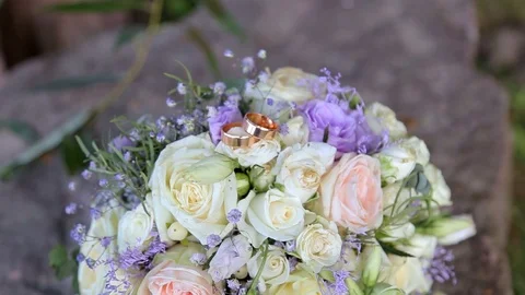 Wedding rings lie on a beautiful bouquet as bridal accessories Vidéo 123780053