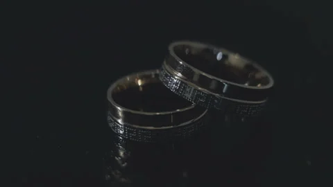 Wedding rings lie on the black table 스톡 동영상 93436175