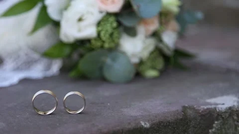 Wedding rings lie on the stone floor Stockbeeldmateriaal 145519082
