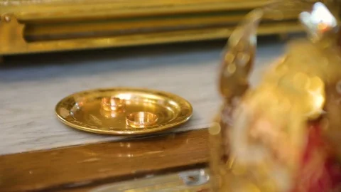 Wedding rings of newlyweds during the consecration of holy water in the church Stock Footage 95588058