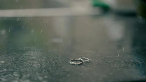 Wedding rings in a puddle at the wedding rainy day Stock Footage 221509350