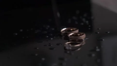 Wedding rings in the rays of yellow light.Wedding rings in rays of light with a  Video stock 141361340