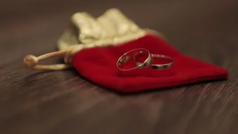 Wedding Rings on a Red Bag on a Table Video stock 241323270