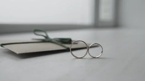 Wedding rings roll towards each other 库存影片 306148120