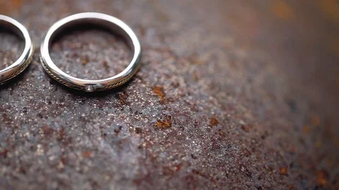 Wedding Rings on rusty metal macro closeup gold and silver diamon Jewellery in Stock Footage 114493840
