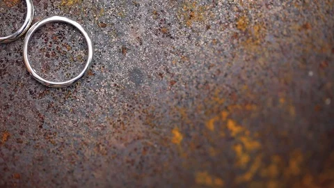 Wedding Rings on rusty metal macro closeup gold and silver diamon Jewellery in Stock Footage 114494015