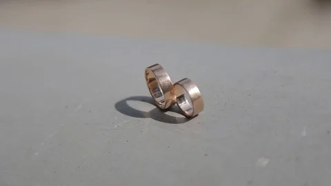Wedding rings stand on a concrete surface Vidéo 123834536