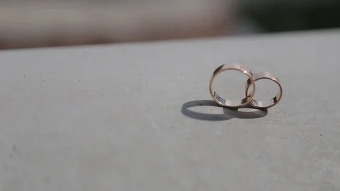Wedding rings stand on a concrete surface Vidéo 123834564
